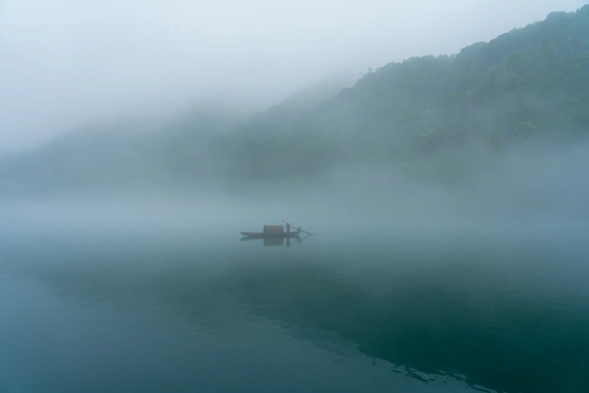 Ein einsames Boot auf dem Dongjiang-See im Morgennebel, Chenzhou